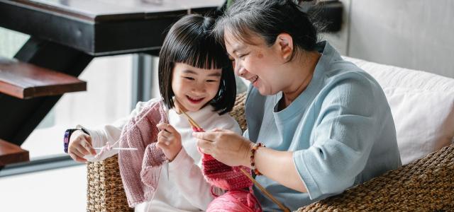 Grandmother and granddaughter knitting together